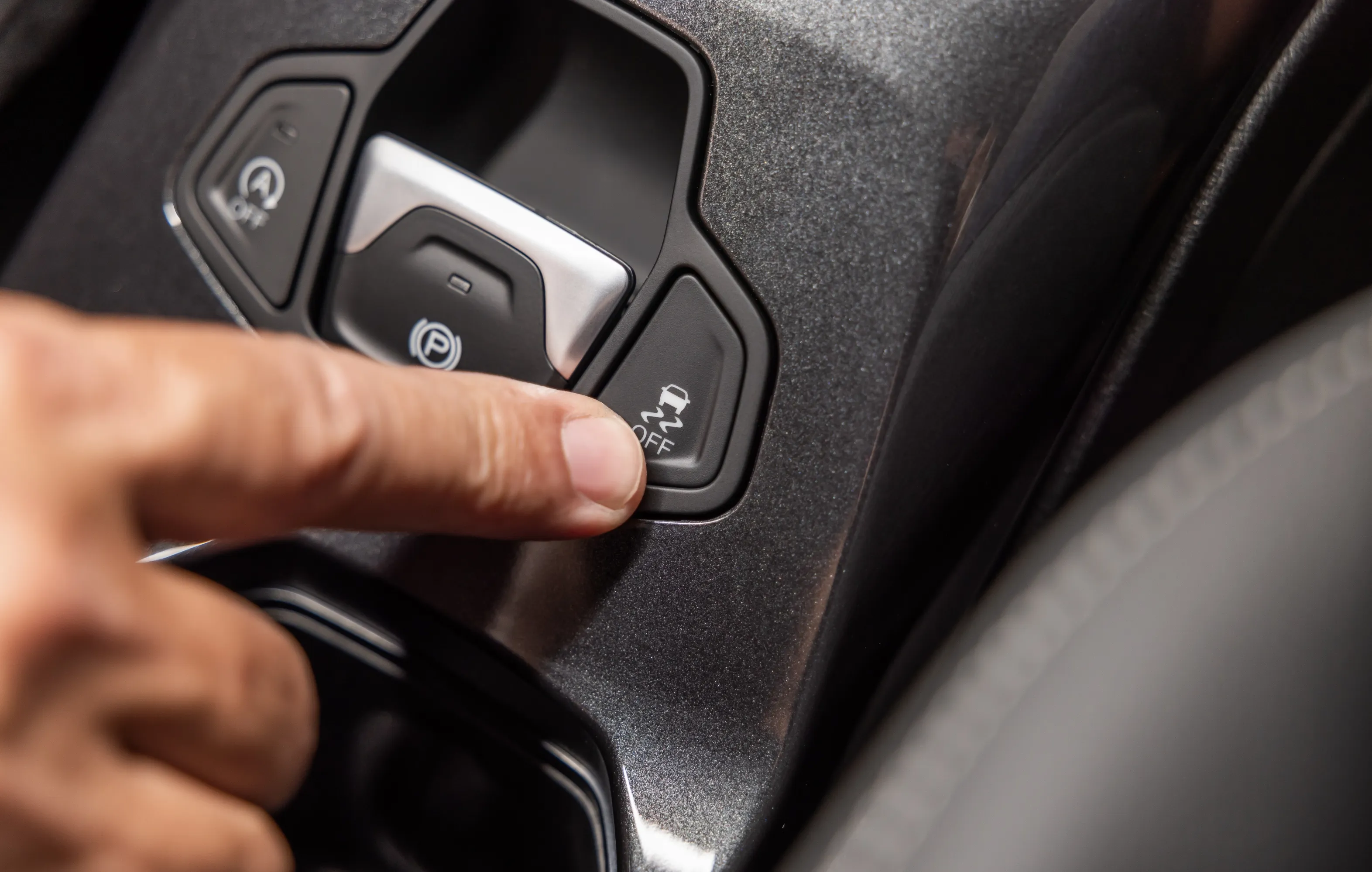 Detalhe do botão de controle de tração presente nas versões 4x2 do Jeep Renegade, ao lado do botão de repartida automática e do freio eletrônico de estacionamento