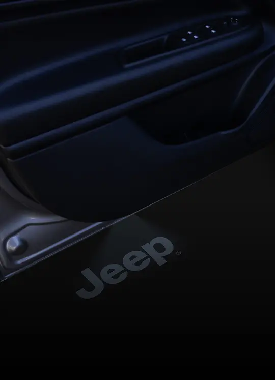 Compartimento porta-objetos interno do Jeep Avenger com logotipo Jeep gravado em acabamento escuro.
