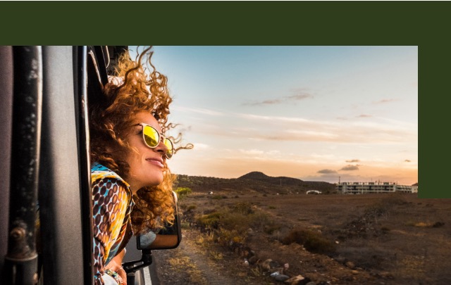 Mulher com óculos de sol olhando para fora da janela de um carro