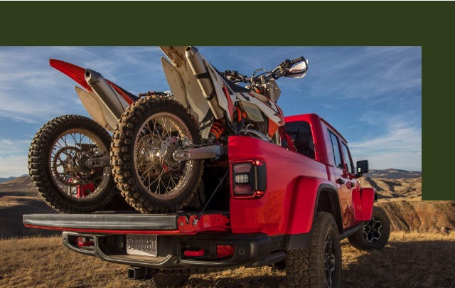 Jeep Gladiator vermelho com duas motos em sua carroceria